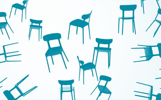 Sedie nere sospese in diverse orientazioni per simboleggiare il pensiero creativo, la composizione visiva e il design concettuale nella comunicazione di design