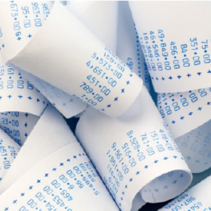 Accounting receipt rolls on a desk, representing financial record-keeping and accounting work.