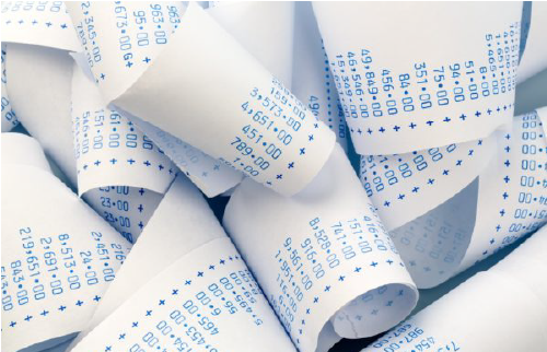 Accounting receipt rolls on a desk, representing financial record-keeping and accounting work.