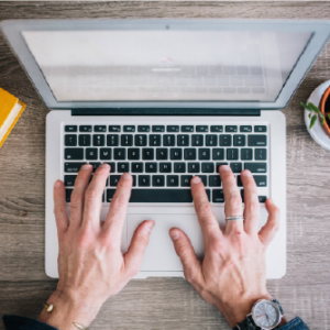 Vista dall'alto di un professionista che utilizza un laptop per seguire un corso di inglese online della durata di un anno