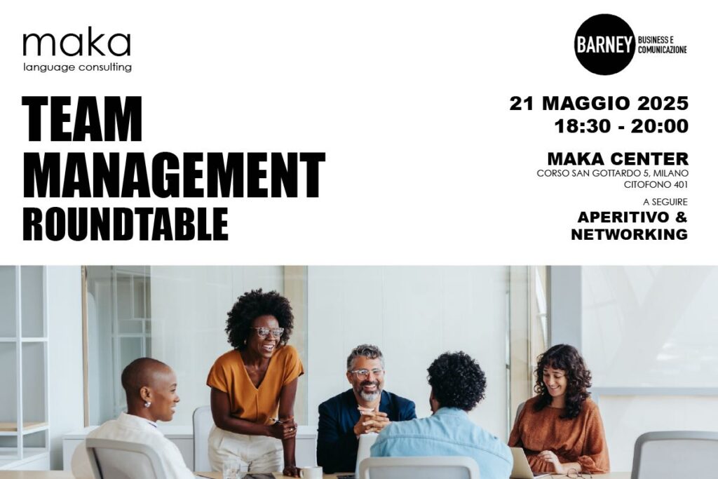 Persone sedute attorno a un tavolo in un contesto professionale, che dialogano e sorridono durante un incontro sul team management