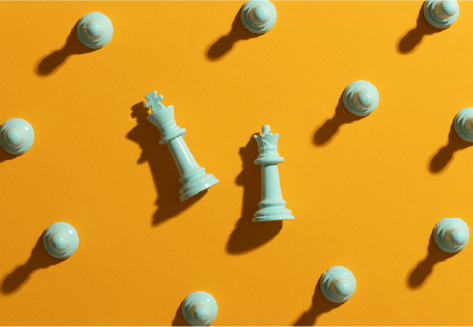 King and Queen chess pieces surrounded by pawns on a yellow background for strategic leadership training