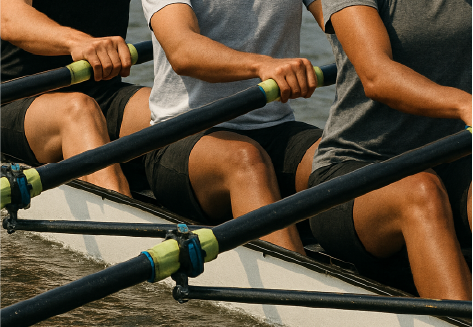 Three people rowing together in perfect sync, symbolizing teamwork and collaboration during Maka Consulting’s Problem Solving & Collaboration course.