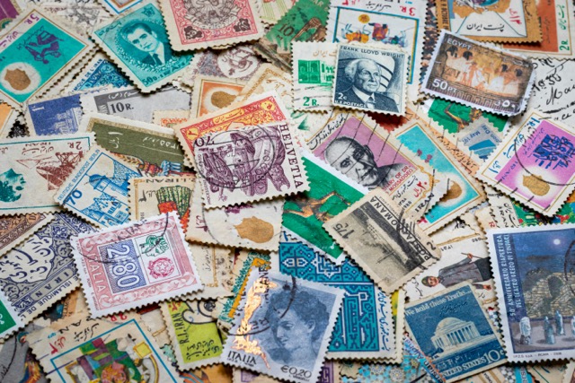 A collection of colorful vintage postage stamps from around the world, featuring different languages, currencies and cultures