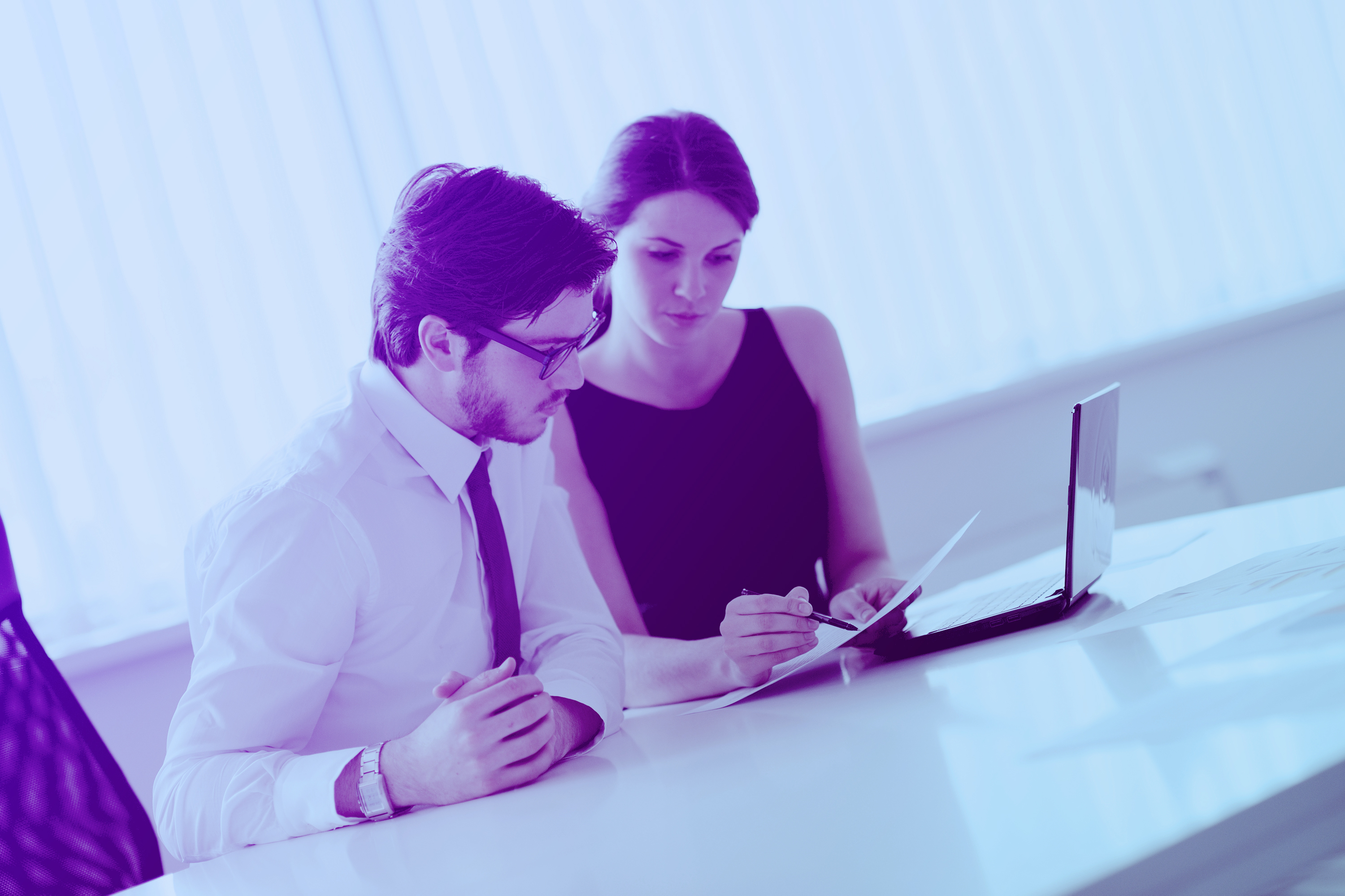 Two company professionals working together at a desk to improve skills at work