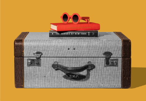 A vintage suitcase with red sunglasses and books on top, representing travel and learning English in 2026
